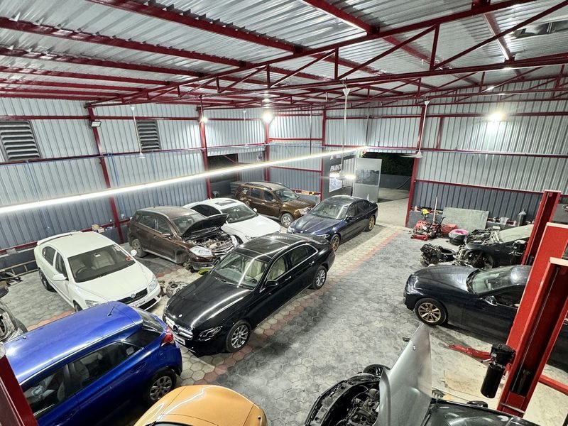 The AS Motorsport workshop floor in Madhapur, bays full of customer cars under the red lift frames